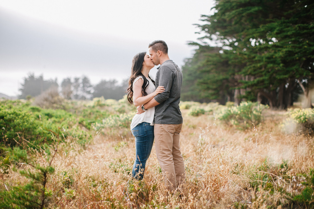A couple kissing in a Point Reyes field