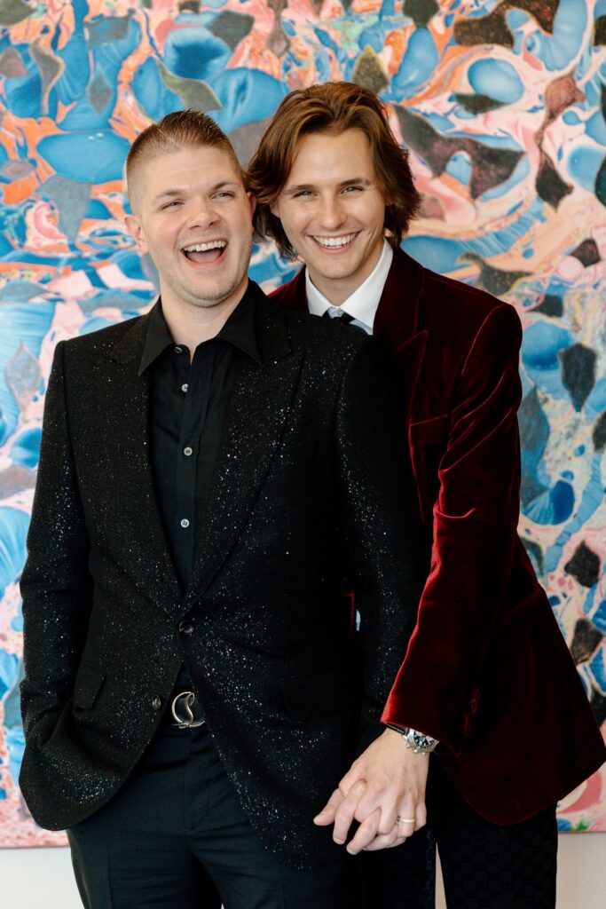 Couple standing in front of painting laughing at the 