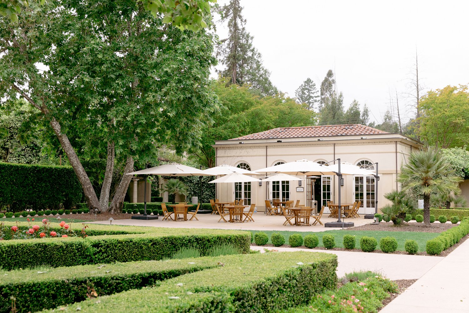 The beautiful outdoor terrace patio and manicured gardens at a fairytale style Chateau St Jean Winery engagement location.
