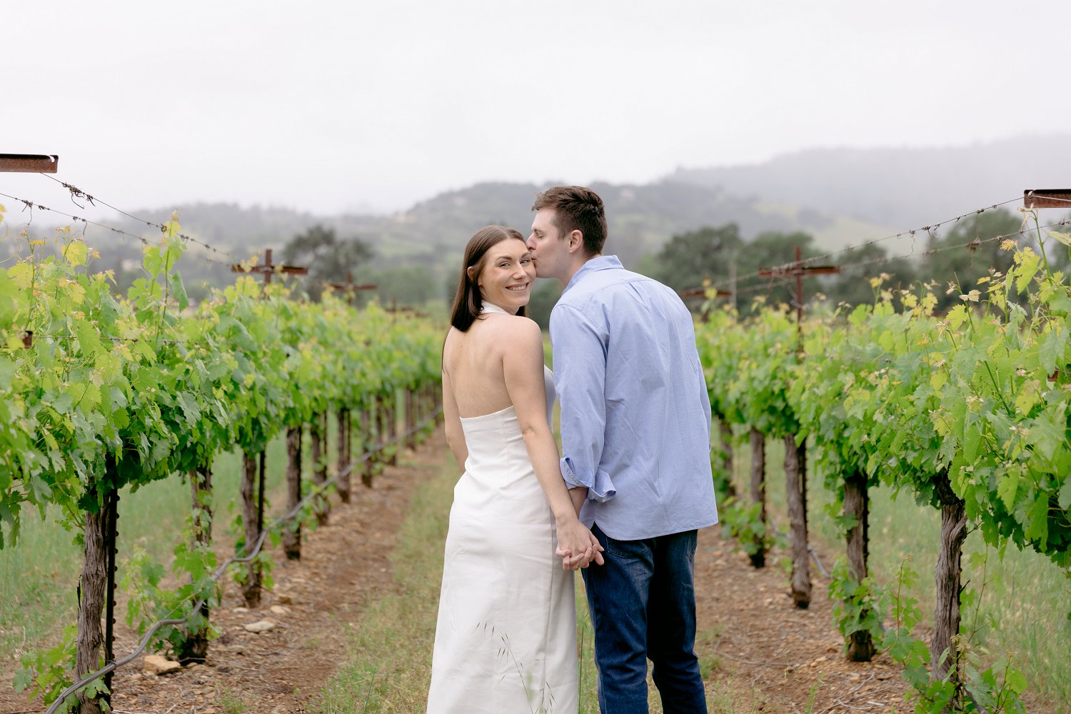A sweet embrace in the vineyards during a romantic fairytale themed Chateau St Jean Winery engagement session in Sonoma.