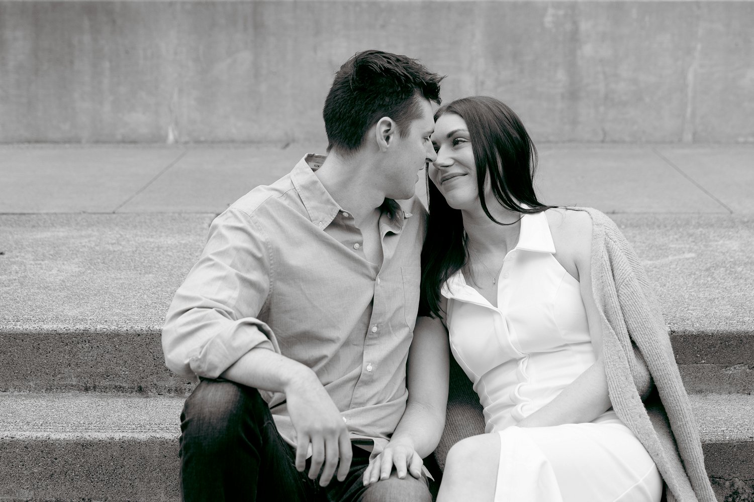 A candid, romantic moment between a couple under the soft, overcast light of a Chateau St Jean Winery engagement