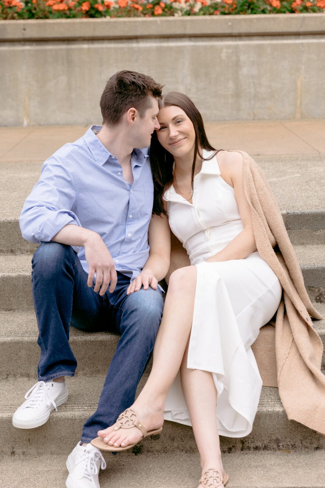 A couple sitting together on the historic stone steps during their morning Chateau St Jean Winery engagement session.