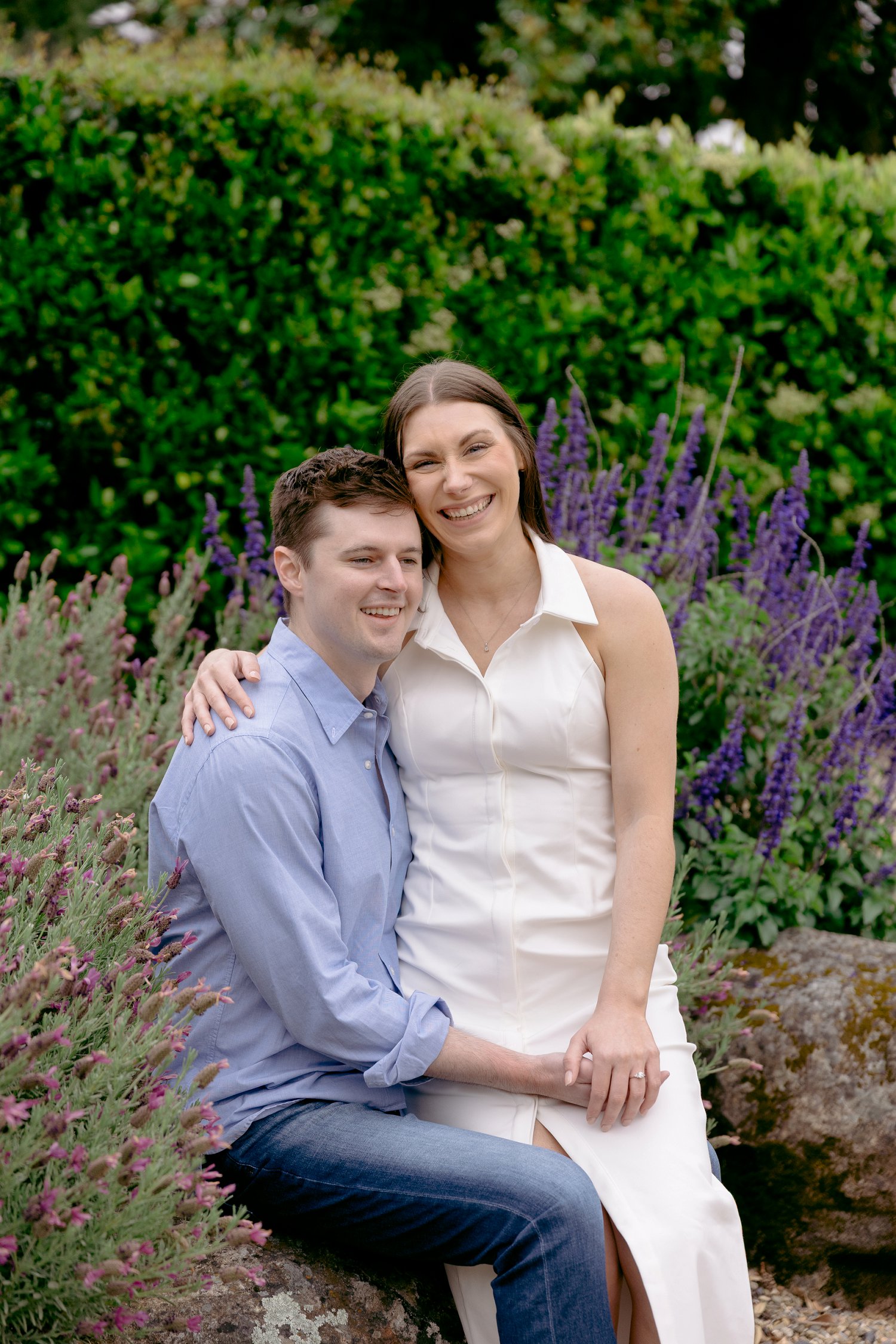 A close-up portrait of a sweet, smiling couple cuddling during their cloudy morning Chateau St Jean Winery engagement.